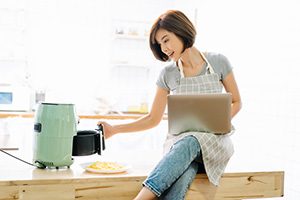 Lady Pre-Heating Her Air Fryer Before Cooking - Air Fryers for Home Use