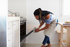 Women Checking Oven - Difference Between an Air Fryer and an Oven